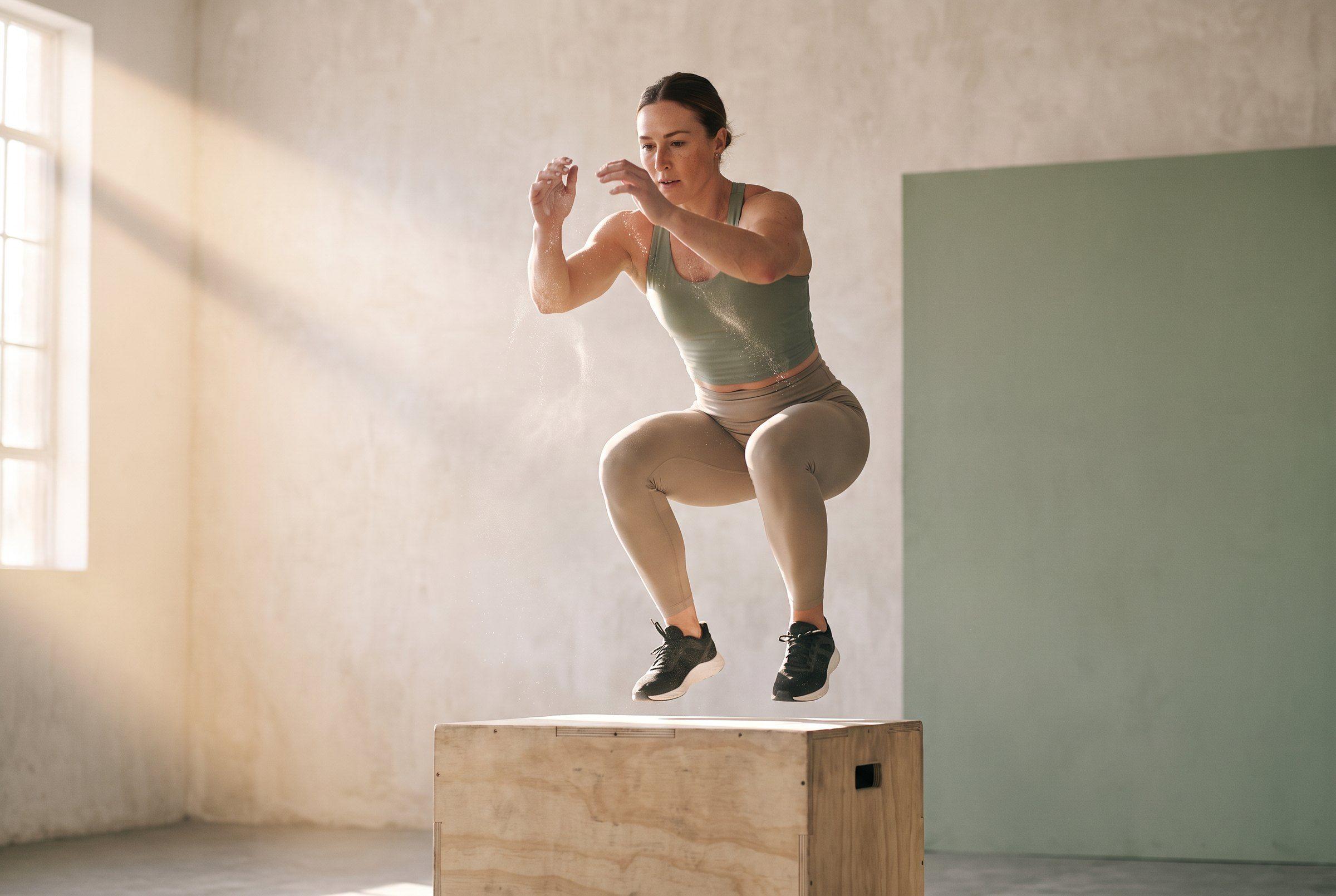 Una mujer en forma en pleno salto al cajón
